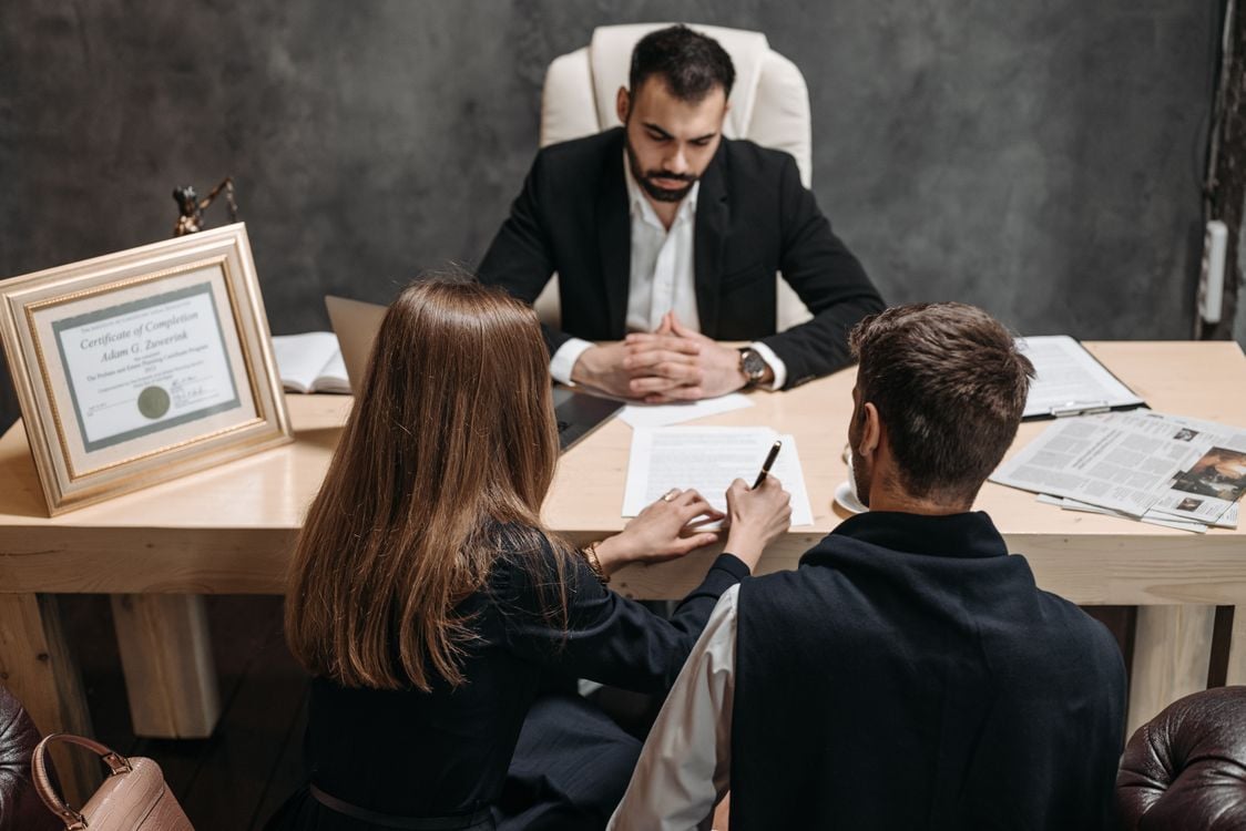 Lawyer reviewing documents with clients in a bright office