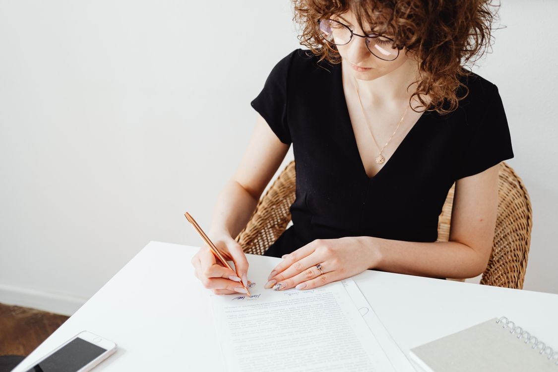 Person reviewing paperwork at a bright table